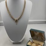 Gold-plated crystal floral necklace and matching earrings on jewellery display