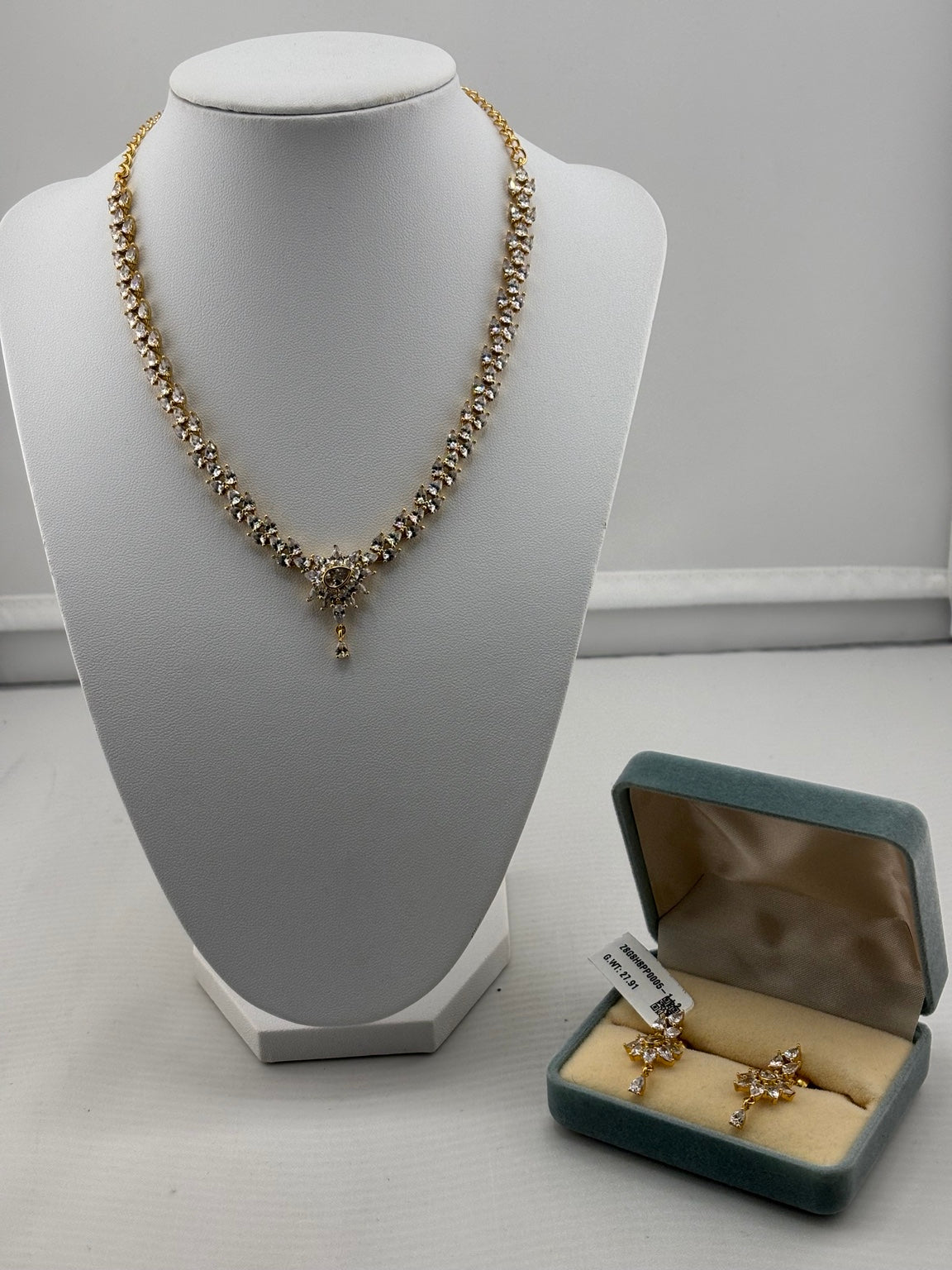 Gold-plated crystal floral necklace and matching earrings on jewellery display